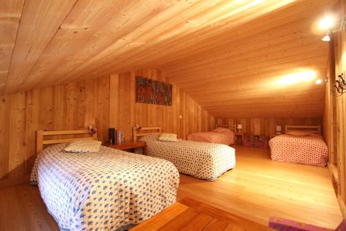 a bedroom with two beds in a wooden cabin at Chalet Barcelonnette in Barcelonnette