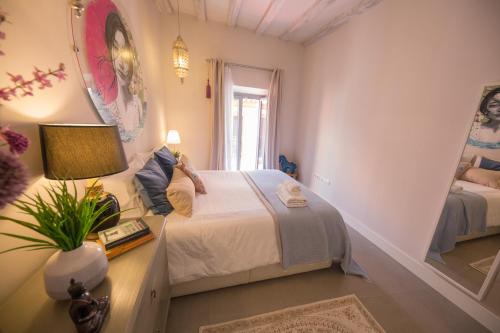 ein Schlafzimmer mit einem Bett und einem Tisch mit einer Lampe in der Unterkunft Awesome Penthouse in Sevilla