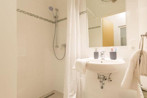 biała łazienka z umywalką i prysznicem w obiekcie Stunning Apartment Vienna Central Station w Wiedniu