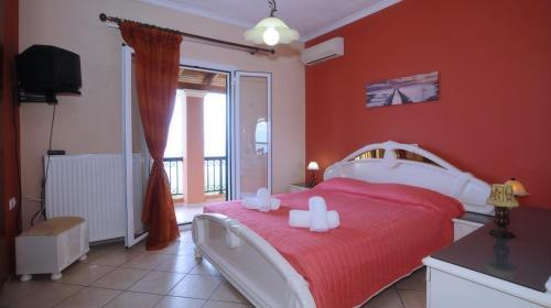 una camera rossa con un letto con due candele sopra di Villa Marianna a Benitses