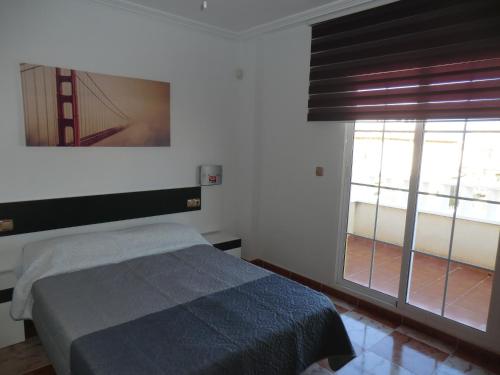 プレヤス・デ・オリフエラにあるCasas Holiday - Lomas de Campoamorのベッドルーム1室(ベッド1台、大きな窓付)