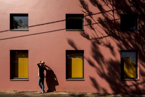 a man dressed as a superhero stands in front of a building at Pink House Azores in Ponta Delgada