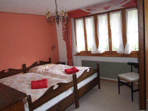 ein Schlafzimmer mit einem Bett mit roten Kissen darauf in der Unterkunft Chalet Kanderhus in Kandersteg