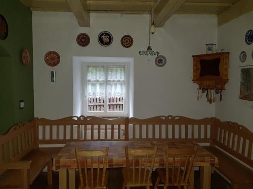a dining room with a wooden table and chairs at Chalupa U Potoka in Staré Hory