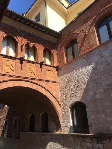a brick building with a bunch of windows at Le stanze di Anna Rita all'Arco Polinori in Foligno