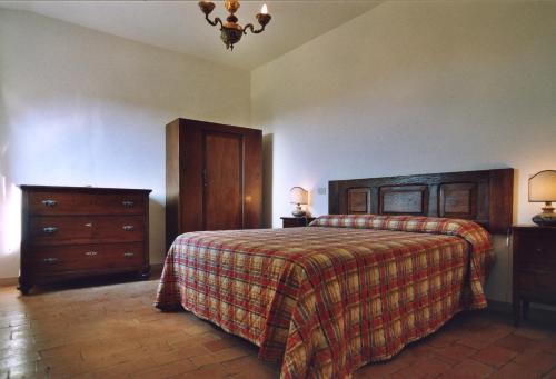 a bedroom with a bed and a dresser at Casale il Colle Deruta in Deruta