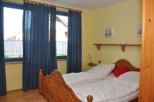 ブットヤーディンゲンにあるParadies-Ferien Burhave - Kat. Iのベッドルーム1室(ベッド1台、青いカーテン付きの窓付)