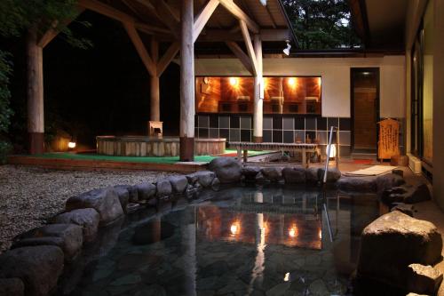 a swimming pool in front of a house at night at Yumoto Fujiya Hotel in Hakone