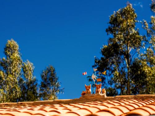 a roof with cats figurines on top of it at Lizzy Wasi Urubamba in Urubamba