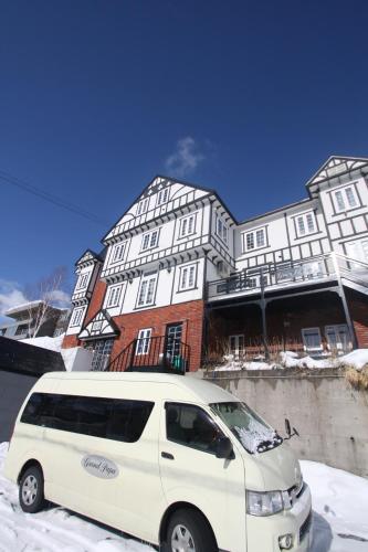 a white van parked in front of a large building at Grandpapa in Kutchan