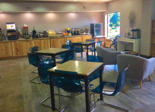 a restaurant with tables and chairs and a kitchen at Baymont by Wyndham O'Fallon St. Louis Area in O'Fallon