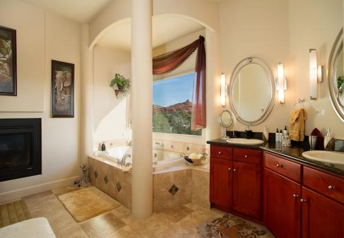 a bathroom with a tub and a sink and a mirror at Sedona Cathedral Hideaway B&B & Spa in Sedona