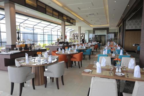 uma sala de jantar com mesas e cadeiras e mesa de cabeceira em Hotel Daily Inn em Jacarta