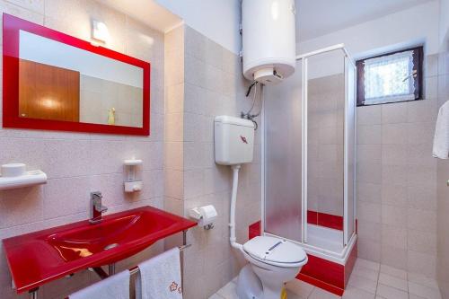a bathroom with a red sink and a toilet at Apartment Lenka in Premantura