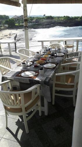 - une table avec des assiettes de nourriture sur la plage dans l'établissement Villa Waru, à Nusa Lembongan