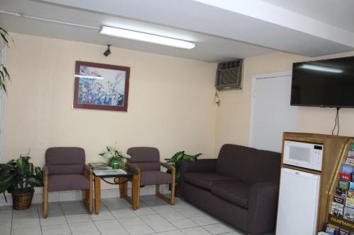 a waiting room with two couches and a flat screen tv at Cascades Motel - Chattanooga in Chattanooga