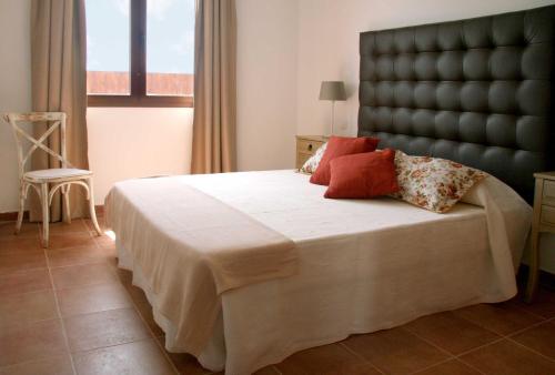 a bedroom with a large bed with a black headboard at Ereza Villas Alicia in Caleta De Fuste