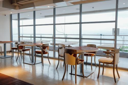 a group of tables and chairs in a room with windows at TRYP by Wyndham Mall of Asia Manila in Manila