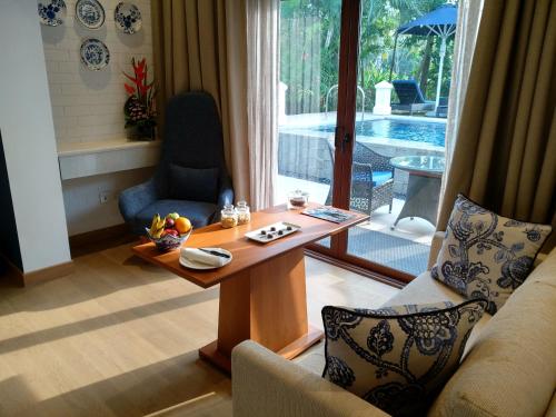 a living room with a table and a couch at Taj Exotica Resort & Spa, Goa in Benaulim