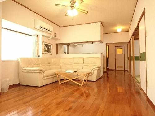 a living room with a white couch and a table at Kokusai Towns Inn in Naha