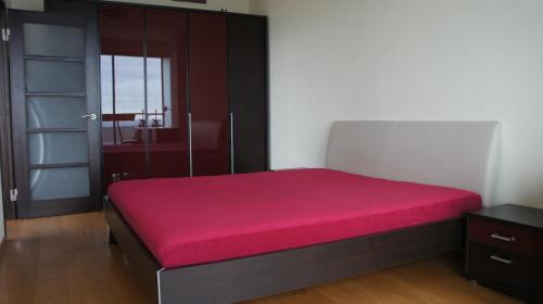 a bedroom with a bed with a red mattress at 25-th Floor Sea View Apartment in Klaipėda