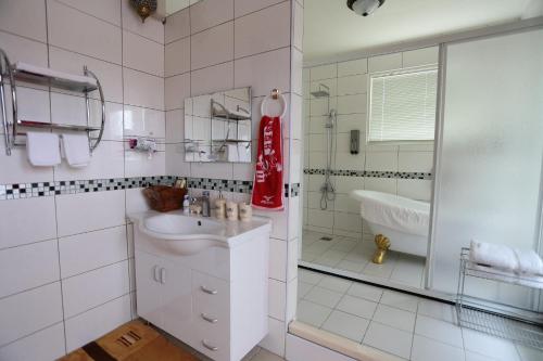 a white bathroom with a sink and a tub at Aria 2 Home (With Elevator) in Hualien City