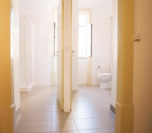 bagno con servizi igienici e corridoio con porta di Olive Street House a Coimbra