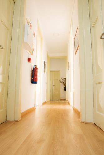 an empty hallway with white walls and wooden floors at Olive Street House in Coimbra