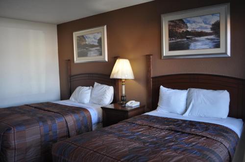 a hotel room with two beds and a lamp at Raider Inn in Lubbock