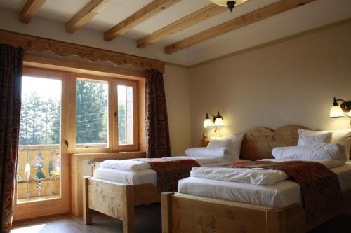 una camera d'albergo con due letti e una finestra di Pensiunea Colt de Rai a Beliş