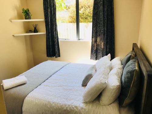 sypialnia z łóżkiem z poduszkami i oknem w obiekcie National Park Home w mieście National Park