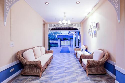 a waiting room with wicker chairs and a hallway at Vieng Tawan Sukhothai Hotel in Sukhothai
