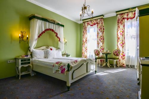 a bedroom with a bed and green walls and windows at Rosen Villa Sibiu in Sibiu