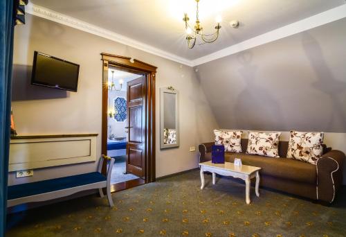een woonkamer met een bank en een tafel bij Rosen Villa Sibiu in Sibiu