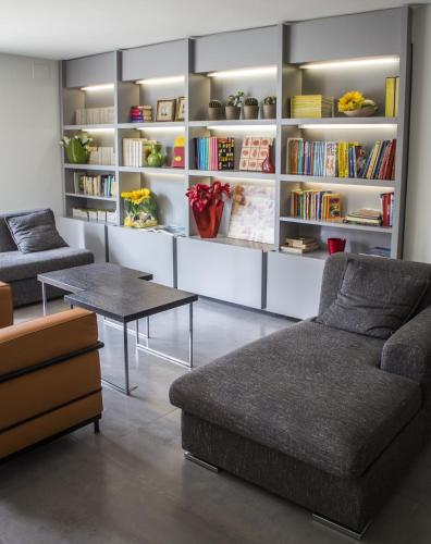 a living room with a couch and a table and bookshelves at Acapulco Hotel in Cattolica