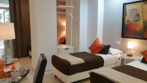 1 dormitorio con 2 camas y mesa con lámpara en InnVatican Guest House, en Roma