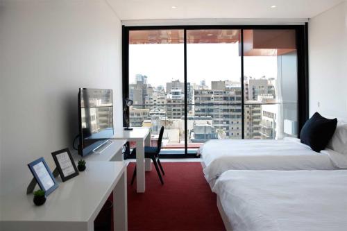 a hotel room with two beds and a desk and a window at 1866 Court & Suites Hotel in Beirut