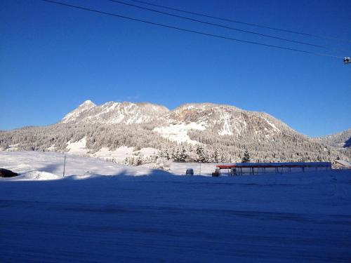 a snow covered mountain in the distance with a train at Ferienhaus Carmen in Grän