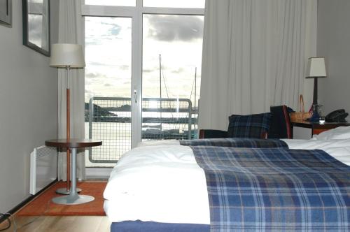 sypialnia z łóżkiem i dużym oknem w obiekcie Hummeren Hotel w mieście Tananger