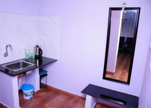 a bathroom with a sink and a mirror at Simply Coorg Estate Villa in Virajpet