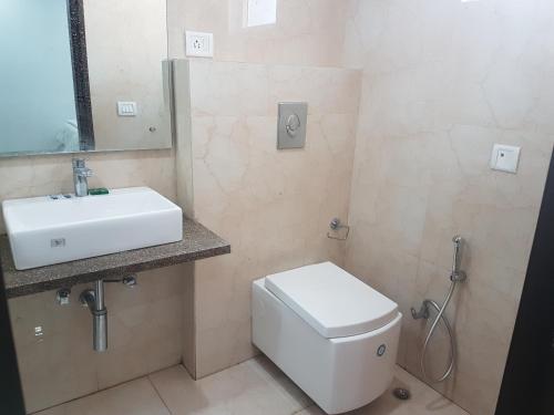y baño con aseo blanco y lavamanos. en Bodhgaya Seven Inn Hotel n Restaurant, en Bodh Gaya