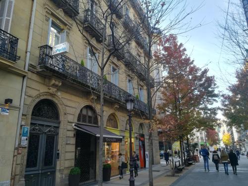 Gente caminando por una calle frente a un edificio en Pensión La Perla, en San Sebastián