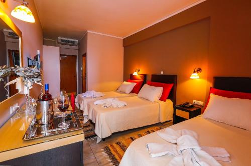 a hotel room with two beds with towels on them at Kyparissia Beach Hotel in Kyparissia