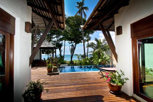 a house with a wooden deck with a swimming pool at Thai Island Dream Estate in Ko Lanta
