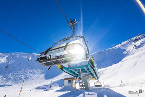 a ski lift going up a snow covered mountain at Hotel Mühlenerhof in Campo Tures