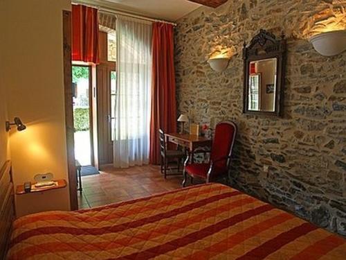 a bedroom with a bed and a table with a dining room at Le Clos des Arts in Les Mages