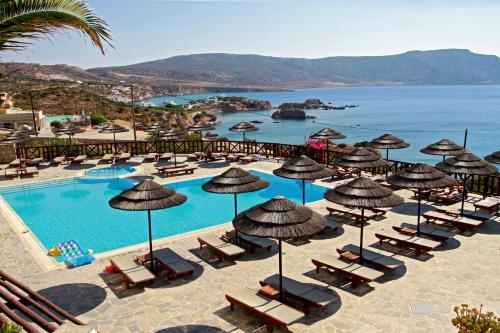 un complexe doté d'une piscine avec des chaises longues et des parasols dans l'établissement Aegean Village Beachfront Resort, à Amoopi