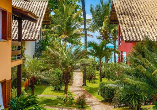 a view of the courtyard of a resort with palm trees at Residence Pé na Areia in Arraial d'Ajuda