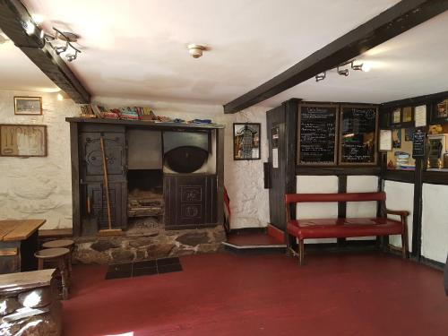 una habitación con un banco y una silla en un restaurante en The Old Dungeon Ghyll Hotel en Great Langdale