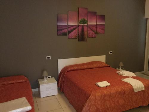 ミラッツォにあるVistamarのベッドルーム1室(ベッド2台付)が備わります。壁にはピンクの花が飾られています。